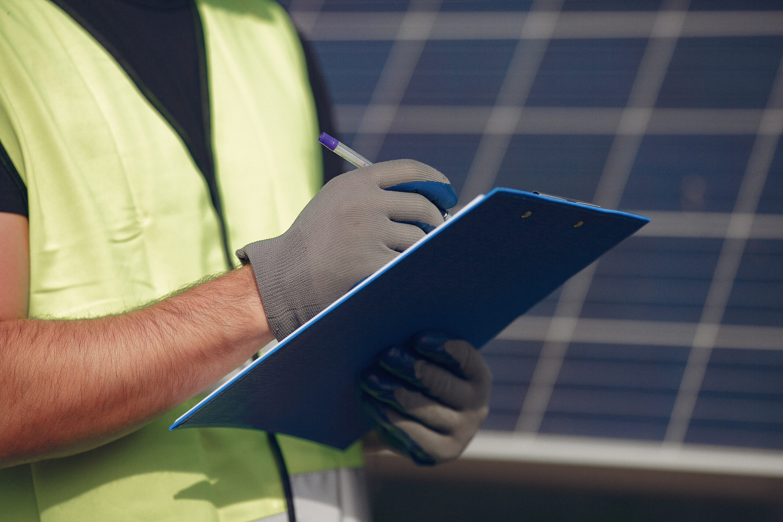 man with white helmet near solar panel scaled